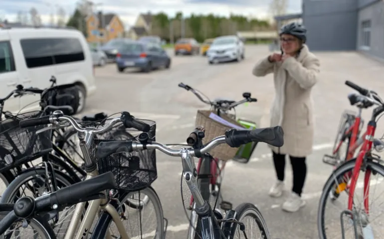 Cykelparkering på en arbetsplats, en kvinna gör sig klar för avfärd. 